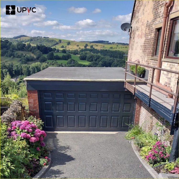 Sprayed double garage door in anthracite grey beneath a brick house